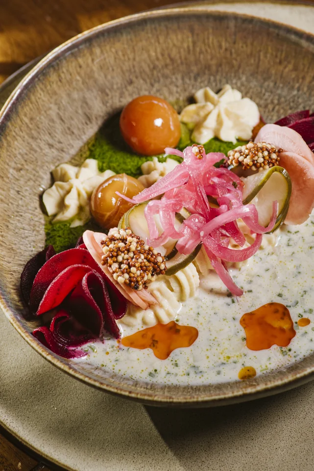 Detalle de un plato de Banús con vegetales y distintas texturas en un cuenco de cerámica.