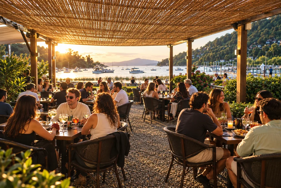 Terraza de Banús Lounge al atardecer, con mesas y vista al lago Villarrica